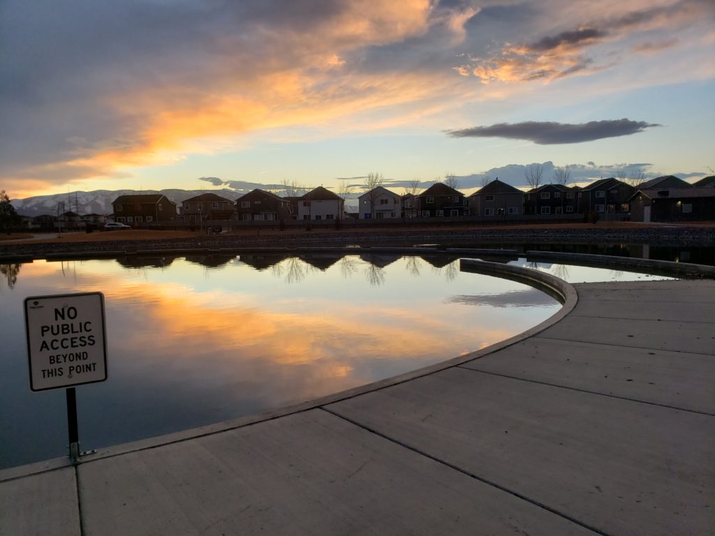 2020 A row of houses between a sunset orange cloud and its reflection in the water below